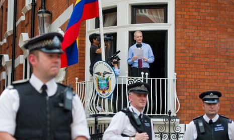 WikiLeaks founder Julian Assange speaks from the Ecuadorian embassy in London in August 2012 as police officers stand guard.