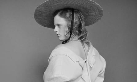 Hanne Gaby Odiele in an oversized white jacket showing her back and a shoulder and a wide-brimmed straw hat.