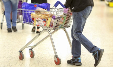 A shopper pushes a trolley at a Tesco store