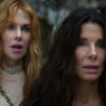 two women stand with surprised expressions