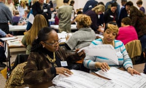 Election workers recount votes as they begin the process of a statewide recount on Wednesday, before a judge’s ruling effectively ended it.