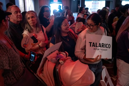People attend a rally, one holding a sign
