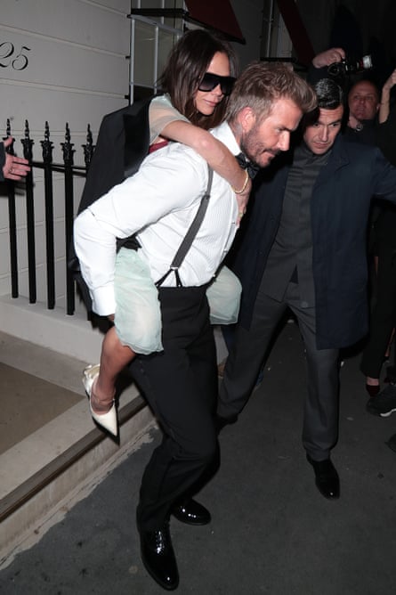 David Beckham carrying Victoria on his back as they leave a venue