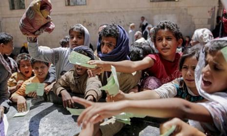 Yemeni children present documents to receive food rations provided by a local charity in Sana’a, Yemen