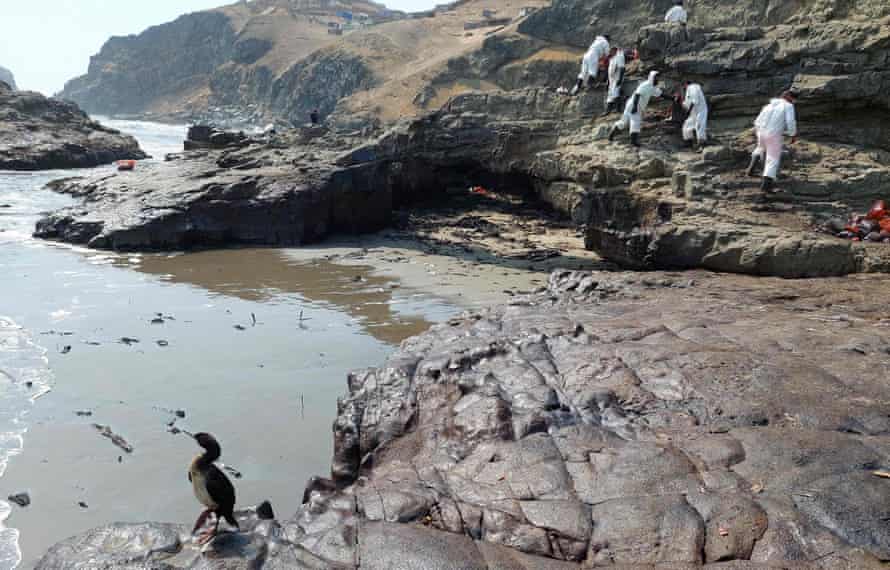 Cleaning crews work to remove oil from a beach in the Peruvian province of Callao