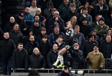 Aston Villa’s Emiliano Buendia celebrates after opening the scoring in front of disgruntled looking Spurs fans.