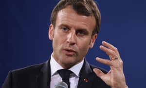 Emmanuel Macron with one hand in the air