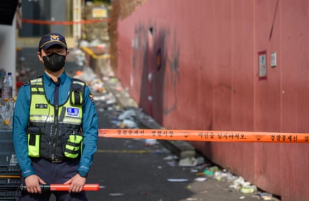 ضابط شرطة يقف للحراسة في مكان الحادث المحاصر الذي شهدته حشود الهالوين القاتلة في منطقة إتايوان