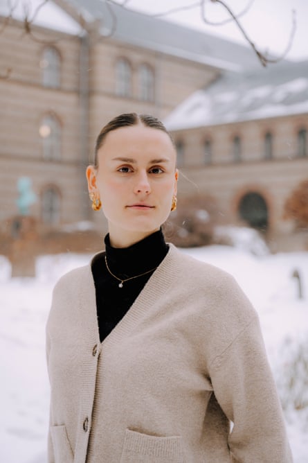 A woman in a black jumper and cream cardigan standing in the snow