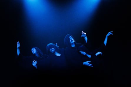 The cast barely visible lit from above by a dark blue light