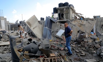 People inspect a destroyed building after an Israeli airstrike in the southern Gaza Strip city of Rafah