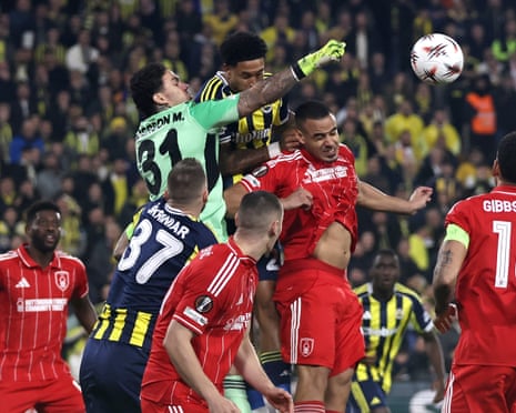 Fenerbahce keeper Ederson punches the ball clear.