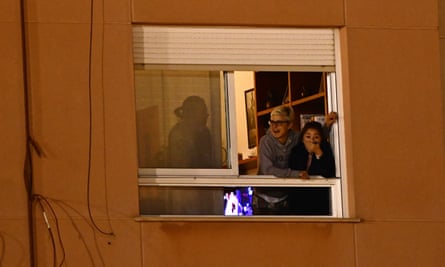 People react from their apartment windows overlooking the ground.