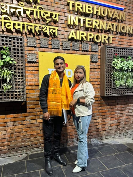 Sulav standing with a companion for a photograph under the sign for Tribhuvan international airport