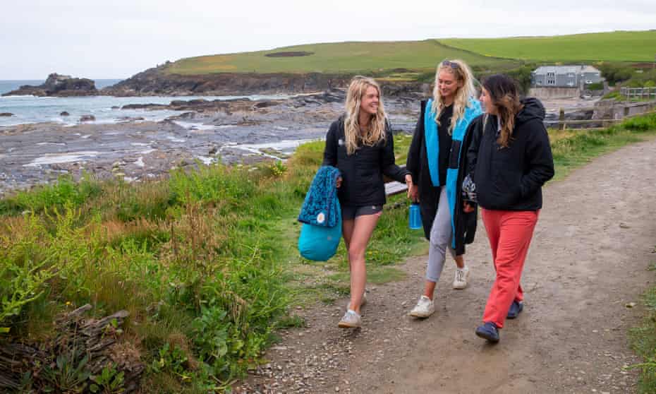 The three friends walking on a path beside the sea