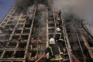 Firefighters climb a ladder while working to extinguish a blaze in a destroyed apartment building after a bombing in a residential area in Kyiv, Ukraine.