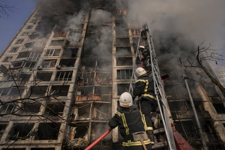 Firefighters climb a ladder while working to extinguish a blaze in a destroyed apartment building after a bombing in a residential area in Kyiv, Ukraine.