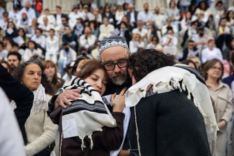 People embrace each other during a Yizkor prayer service
