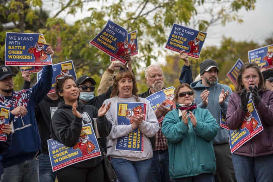 people wave signs that say 'we stand with battle creek workers'