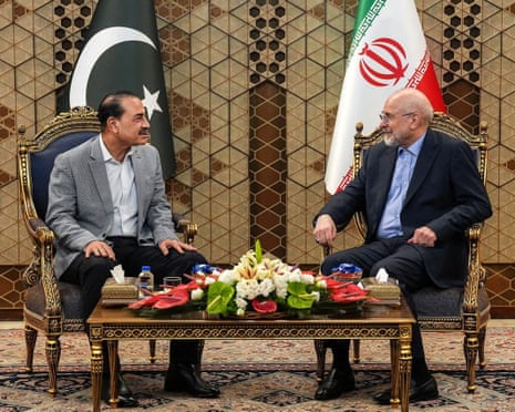 Field Marshal Asim Munir and Mohammad Bagher Ghalibaf sit facing each other, with the flags of Pakistan and Iran behind them