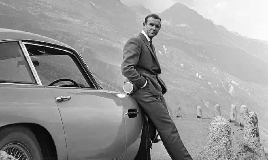 Sean Connery poses as James Bond next to his Aston Martin in Goldfinger.