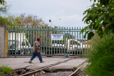A man walks by a fence with a sign saying ‘Private property, Zinc Nacional’ in Spanish.