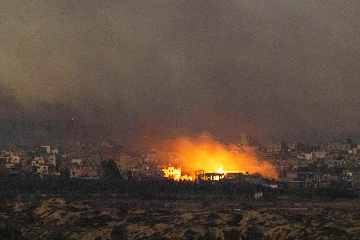 A fire amid destroyed buildings.