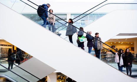 Shoppers ride up an escalator in the John Lewis flagship store on Oxford Street in London