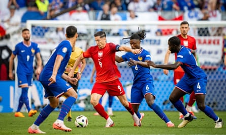 Robert Lewandowski of Poland escapes the challenge of France’s Eduardo Camavinga