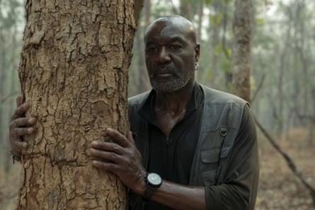 Delroy Lindo in a scene from Spike Lee’s Da 5 Bloods where he is behind a tree in a forest