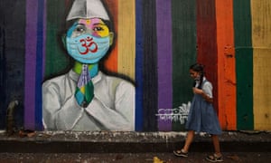A school girl walks past a Covid-19 mural in Mumbai, India, on 1 December.