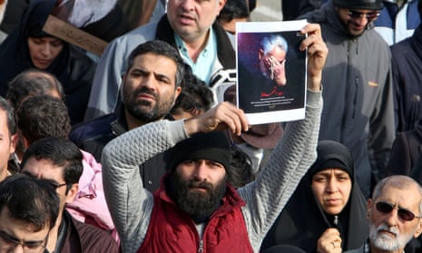 A man holds a picture of Qassem Suleimani during a demonstration in Tehran on Friday.