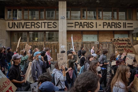 Protesters walk past a university building