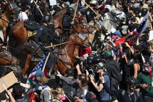 Demonstrators standoff against law enforcement on horseback during a protest in Los Angeles
