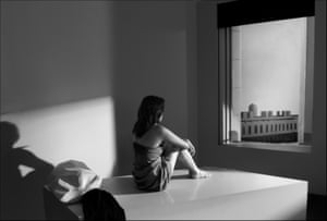 A seated woman looks out of a window