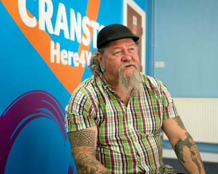 Roy Stokes sits in front of a wall in a room that says ‘Cranstoun Here 4 You’