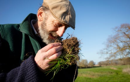 John Cherry of Weston Park Farms inspects and smells the soil in one of his fields.