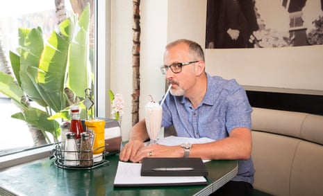 Sam Bain, co-writer of Peep Show, drinking a milkshake at a table