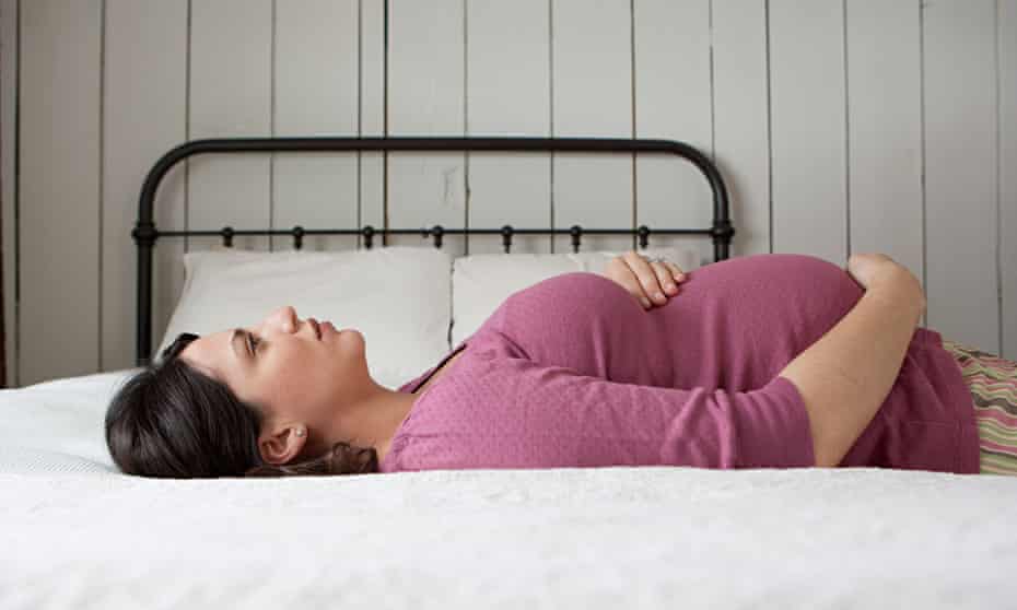 pregnant woman lying on bed