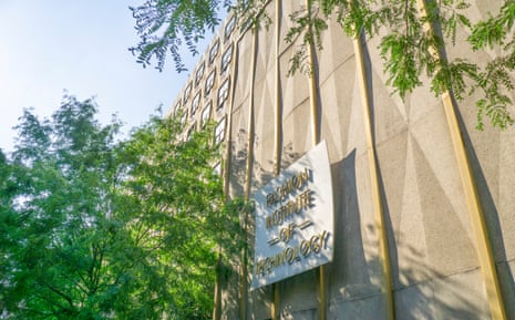 A sign reading 'Fashion Institute of Technology' on a building facade, surrounded by tree branches