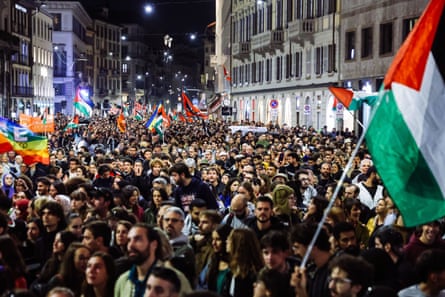 Crowds of people fill a street in Rome waving Palestinian flags
