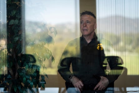 man in uniform puts hands on hips as seen through window