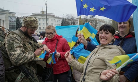Women waving flags; soldier signing a Ukrainian flag.