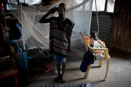 Timon Kamis, 10, salutes like a soldier in the shelter he shares with his family in Malakal, South Sudan.