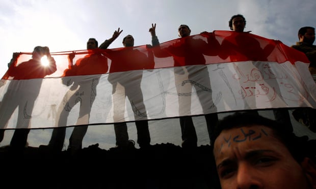 Anti-government protesters hold an Egyptian flag during a mass demonstration in Tahrir Square in Cairo, in February 2011.