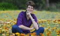 Glenda Parkin siting in a field of flowers smiling