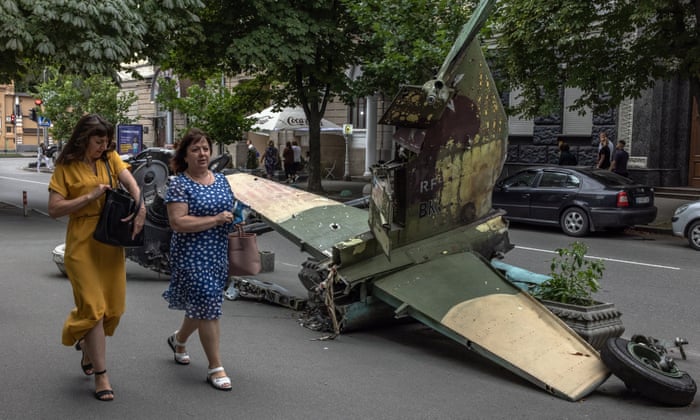Two women walk past the tail part of a Russian attack aircraft Su-25SM destroyed in downtown Kyiv, Ukraine, 9 August.