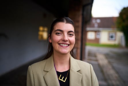 Eilís Sexton of the Line Youth Project smiles outdoors, with buildings blurred behind her
