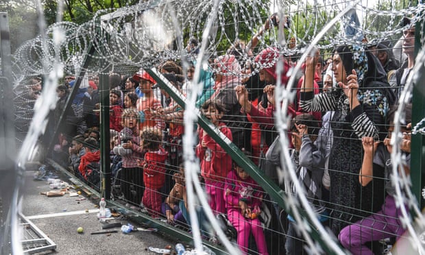 Refugees stand behind a fence at the Hungarian border with Serbia in September 2015.