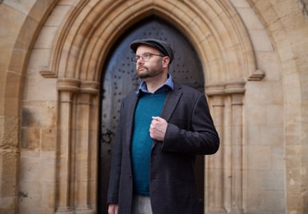 Symon Hill, who was arrested for asking who elected King Charles, standing in front of a church door